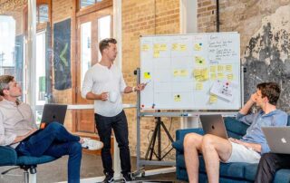Mike Edwards Joins the Startup Visa Canada Team, image showing a man presenting something to a team in a meeting room